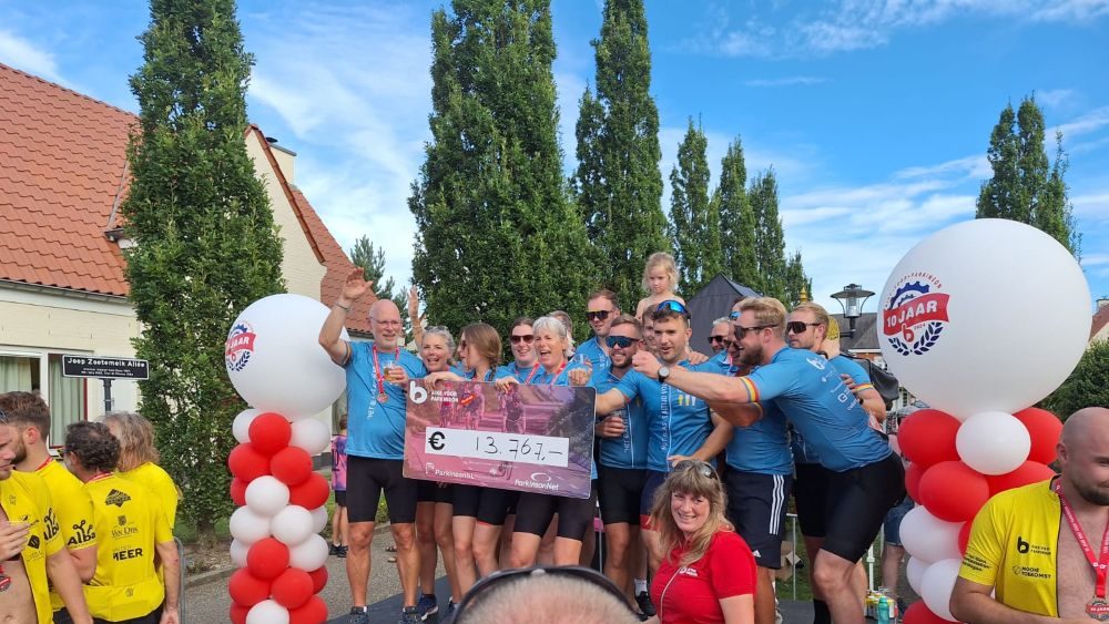 Jan van Hasselt viert eindbedrag van zijn team tijdens bike en hike voor parkinson